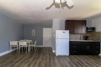 a kitchen with a white refrigerator and a table at Sun Beach Inn in Hollywood