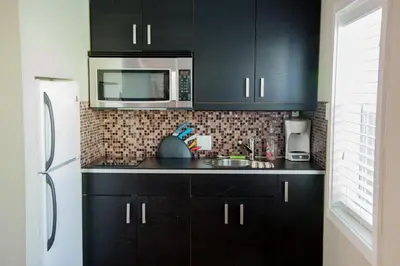 a kitchen with black cabinets and a white refrigerator at Sun Beach Inn in Hollywood
