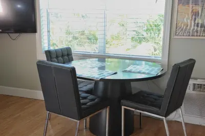 a dining room table with four chairs and a window at Sun Beach Inn in Hollywood