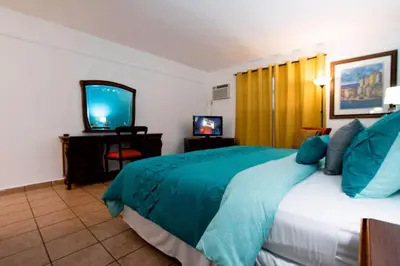 a hotel room with a bed and a television at Gables Inn in Miami