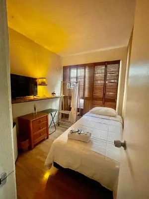 a bedroom with a bed and a desk and a television at Habitación Céntrica calle 8 Miami in Miami
