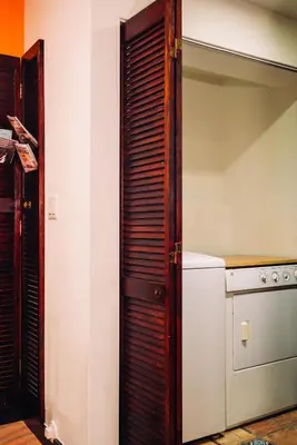 a kitchen with a wooden door next to a refrigerator at Renovated Historic Coconut Grove Cottage Home in Miami