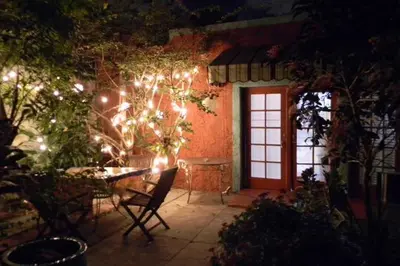a patio with a table and a door with lights at The Wild Rose in Miami