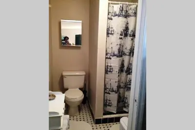 a bathroom with a toilet and a shower curtain at The Wild Rose in Miami