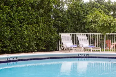 two lawn chairs sitting next to a swimming pool at Lovely apartment on the canal with a pool in Fort Lauderdale