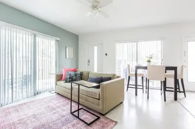 a living room with a couch and a table at Lovely apartment on the canal with a pool in Fort Lauderdale
