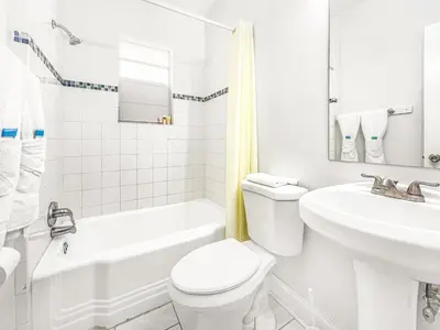 a white bathroom with a toilet and a sink at Paradise Oceanfront by HBH in Hollywood