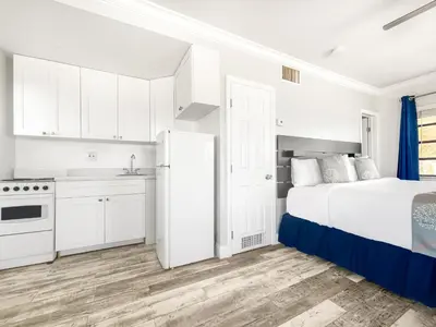 a white bedroom with a bed and a kitchen at Paradise Oceanfront by HBH in Hollywood
