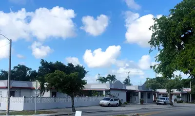 a street with cars parked in front of a building at Ramona Motel in Miami