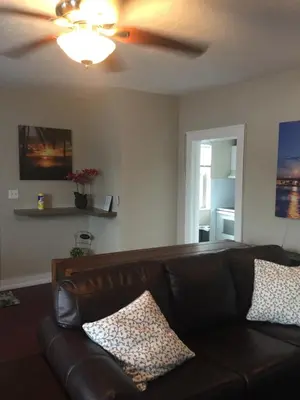 a brown leather couch in a living room with a ceiling fan at Modern 2/1 Apt near Midtown and Beaches in Miami
