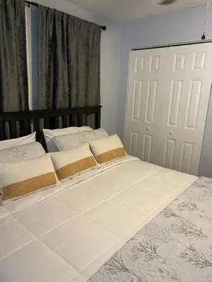 a bedroom with a large white bed and a door at Modern 2/1 Apt near Midtown and Beaches in Miami