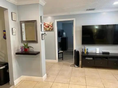 a living room with a large flat screen tv on a wall at Modern 2/1 Apt near Midtown and Beaches in Miami