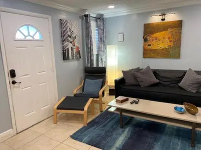 a living room with a black couch and a table at Modern 2/1 Apt near Midtown and Beaches in Miami