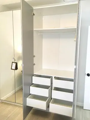 a walk in closet with white cabinets and a mirror at A Suite Retreat in Miami