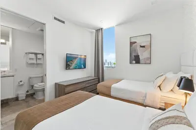 a hotel room with two beds and a bathroom at MILLA South Beach in Miami Beach