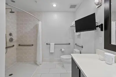 a white bathroom with a shower and a toilet at Provident Doral At The Blue in Miami