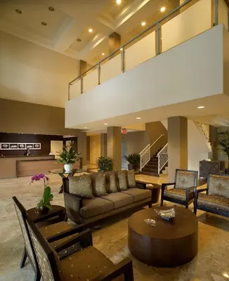 a lobby with a couch and chairs and a table at Provident Doral At The Blue in Miami