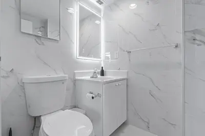 a white bathroom with a toilet and a shower at Great Apartment with beach access in Hollywood