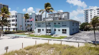 a building with palm trees in front of buildings at Shore View Hotel in Hollywood