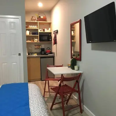 a bedroom with a table and chairs and a kitchen at Walk to Restaurants and Shops - 5S in Miami