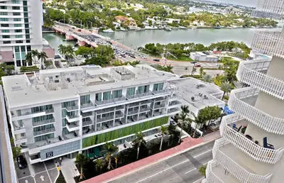 an aerial view of a large white building with a body of water at 6080 Design Hotel by Eskape Collection in Miami Beach