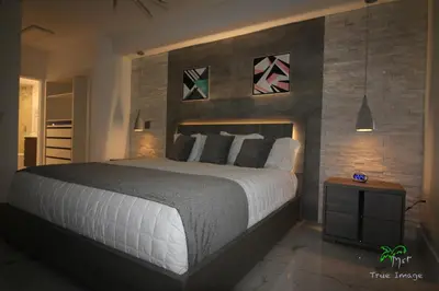 a bedroom with a large bed and some paintings on the wall at Yacht Club at Aventura 2 Bed 2 bath Luxurius Cozy Brand New in Aventura