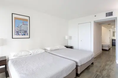 two beds in a bedroom with white walls at 4 BDR Sweeping Bayfront Elegance in Miami