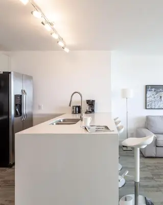 a white kitchen with a sink and a refrigerator at 4 BDR Sweeping Bayfront Elegance in Miami