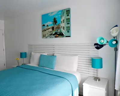 a bedroom with a blue and white bed with blue lamps at Snooze in Fort Lauderdale