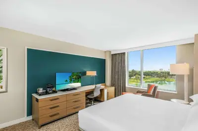 a hotel room with a bed and a desk with a television at Hilton Miami Dadeland in South Miami