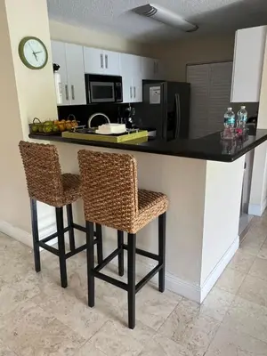 a kitchen with two bar stools and a counter top at Renovated 2/2 Unit at Yacht Club/Aventura in Aventura