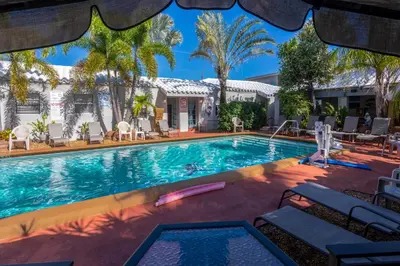 a swimming pool with chairs and a house at Richard's Motel in Hollywood