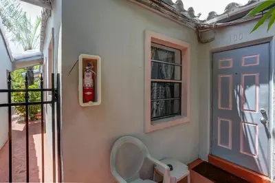 a fire extinguisher on the wall of a house with a door at Richard's Motel in Hollywood