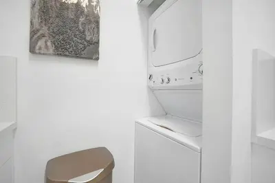 a white bathroom with a sink and a refrigerator at Miami Brickell 4 Bedrooms High Ceiling loft on the pool in Miami