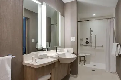 a bathroom with a sink and a mirror and a shower at SpringHill Suites by Marriott Fort Lauderdale Miramar in Miramar