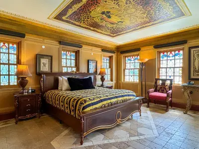 a bedroom with a bed and a ceiling with a painting at The Villa Casa Casuarina in Miami Beach