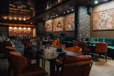 a dining room with tables and chairs and paintings at DoubleTree by Hilton Grand Hotel Biscayne Bay in Miami