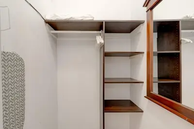 a walk in closet with white walls and wooden shelves at James Hotel in Miami Beach