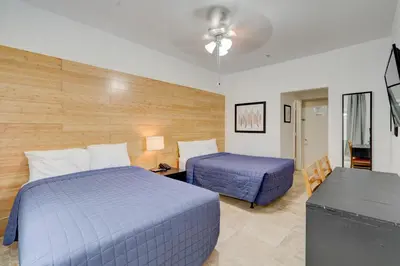 a hotel room with two beds and a table and a desk at James Hotel in Miami Beach