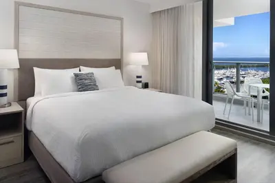 a bedroom with a large bed and a balcony at Courtyard Miami Coconut Grove in Miami