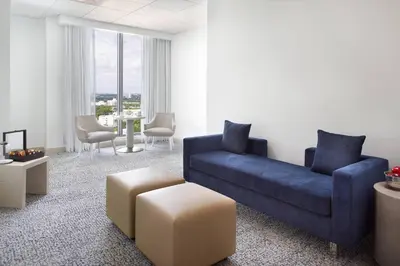 a living room with a blue couch and a table at Courtyard Miami Coconut Grove in Miami