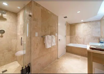 a bathroom with a shower and a tub and a sink at 1 Hotel & Homes Miami Beach Oceanfront Residence Suites By Joe Semary in Miami Beach