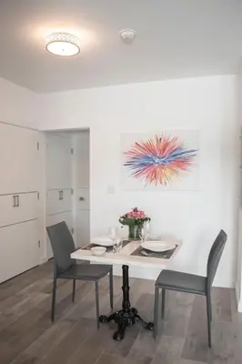 a dining room with a table and chairs and a painting at Sobe Lux in Miami Beach