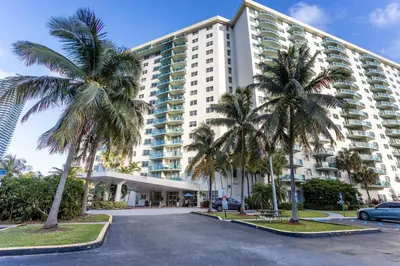 a large building with palm trees in a parking lot at Luxury Miami Condos in Miami Beach
