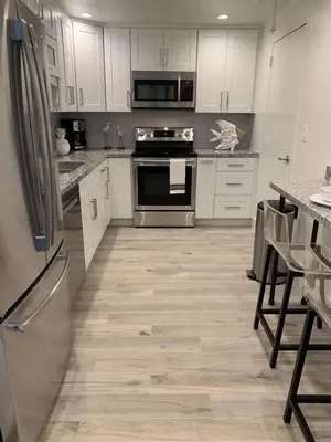 a kitchen with white cabinets and stainless steel appliances at Direct Ocean View Condo at Tides of Hollywood - 7N in Hollywood