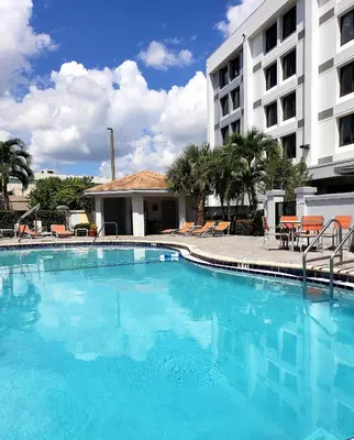 a large blue swimming pool in front of a hotel at Holiday Inn Express & Suites Miami - Hialeah by IHG in Hialeah