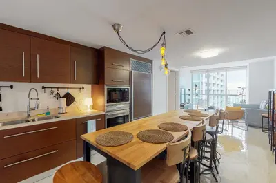 a kitchen with a long wooden table with chairs at Iconic Views in Miami