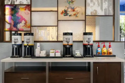 a counter with bottles of coffee on a table at Hampton Inn & Suites Fort Lauderdale Airport in Hollywood