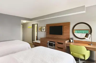 a hotel room with two beds and a desk with a television at Hampton Inn & Suites Fort Lauderdale Airport in Hollywood