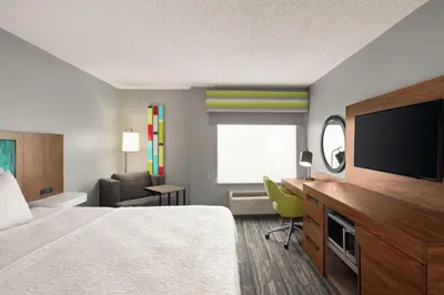 a hotel room with a bed and a flat screen tv at Hampton Inn & Suites Fort Lauderdale Airport in Hollywood